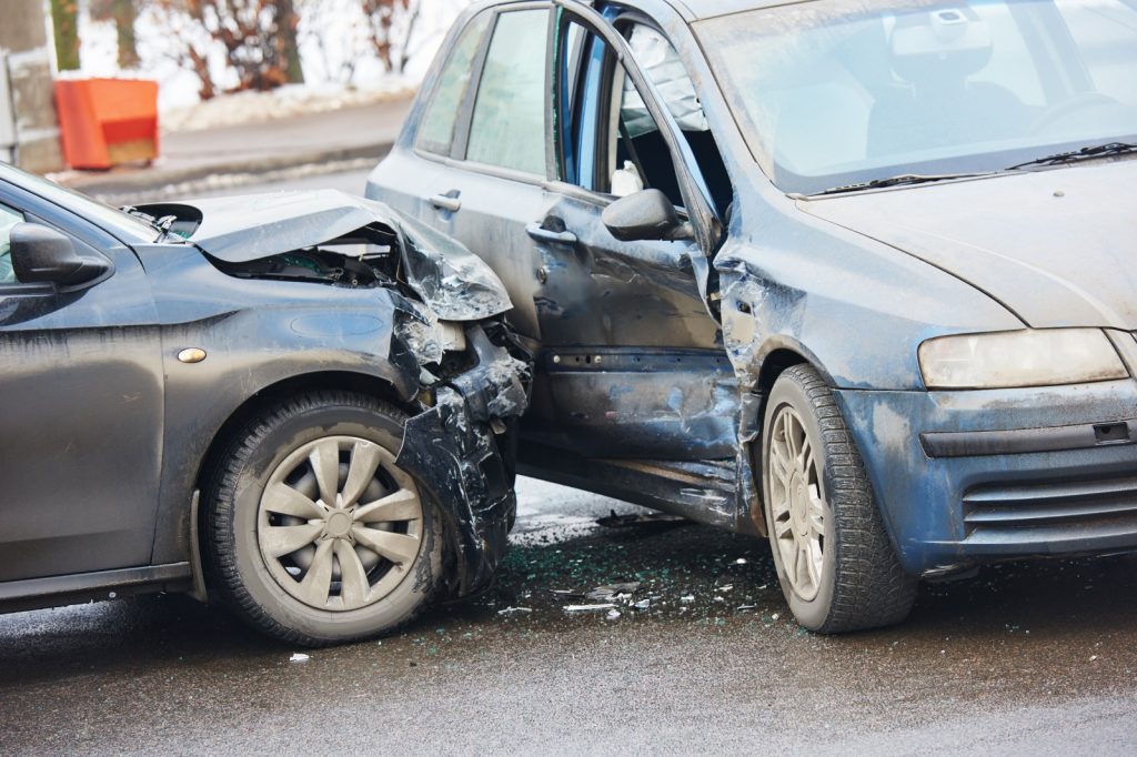 Twee zwaar beschadigde auto’s na een botsing op een nat wegdek, vermoedelijk total loss verklaard