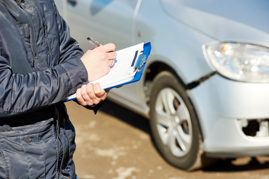 Schade-expert inspecteert autoschade en noteert bevindingen op een formulier