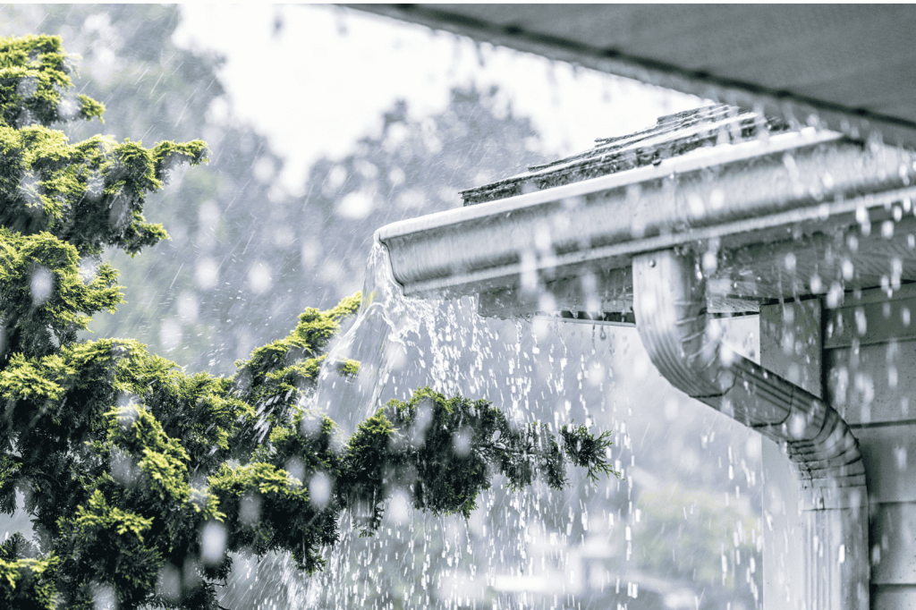 Overlopende dakgoot tijdens hevige regen, met risico op waterinsijpeling en vervolgschade